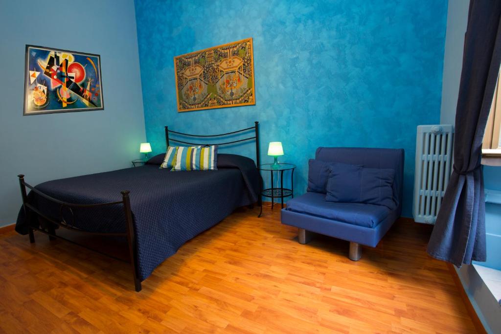罗马拉特兰诺酒店的一间拥有蓝色墙壁的卧室,配有一张床和一张蓝色椅子