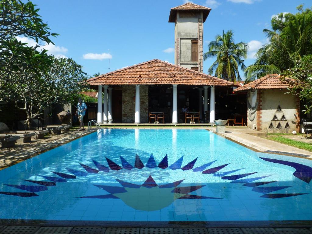 尼甘布阿拉利亚别墅酒店的别墅前的游泳池