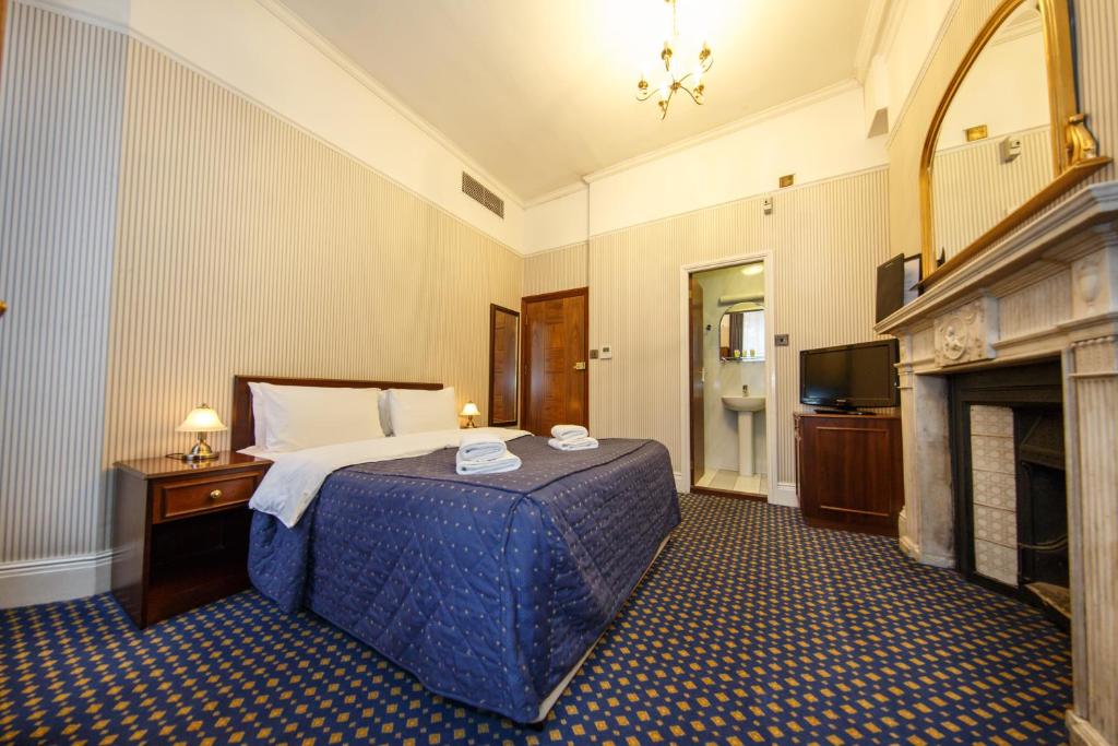 伦敦摄政大楼酒店的酒店客房配有一张床和一个壁炉。
