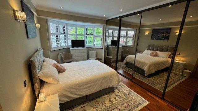 伦敦Stunning double bedroom Greenwich London with private bathroom的一间卧室配有两张床和镜子