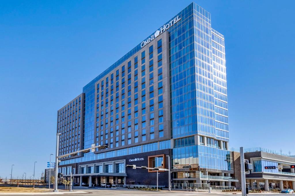 俄克拉何马城Omni Oklahoma City Hotel的一座高大的玻璃建筑,上面有标志