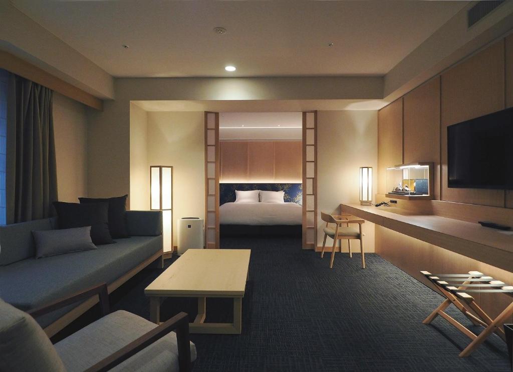 京都京都诺库酒店的酒店客房设有一张沙发和一张床