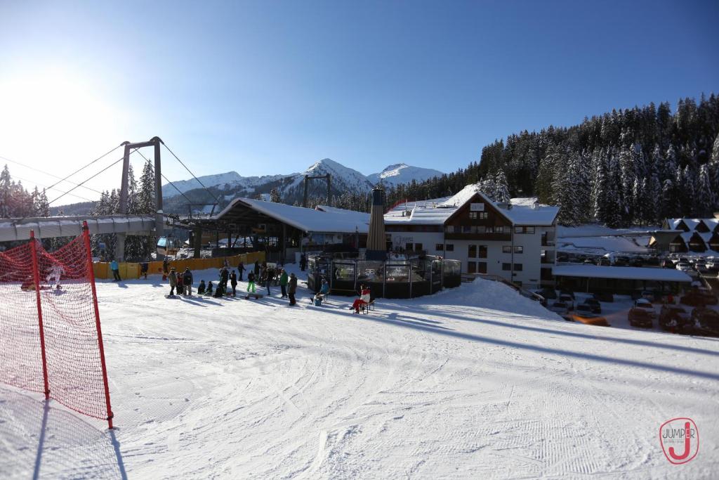 摩德纳迪-坎皮格里奥弗蒂尼酒店的一群人沿着雪覆盖的斜坡滑雪