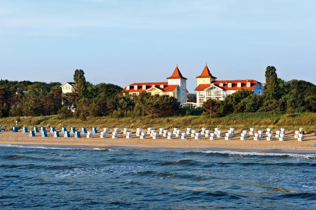 奥斯特西巴德钦诺维茨Hotel Kleine Strandburg - Adults Only的海滩上摆放着白色的遮阳伞和椅子