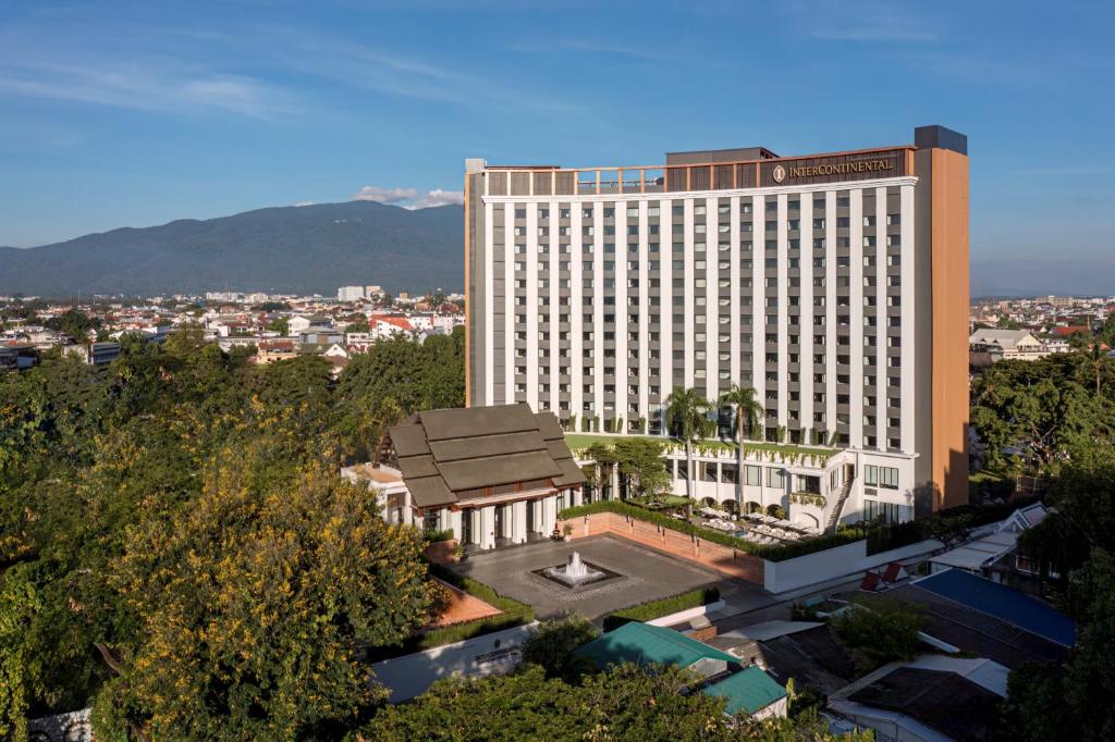 清迈InterContinental Chiang Mai The Mae Ping, an IHG Hotel的一座大型酒店建筑,前面有一个公园