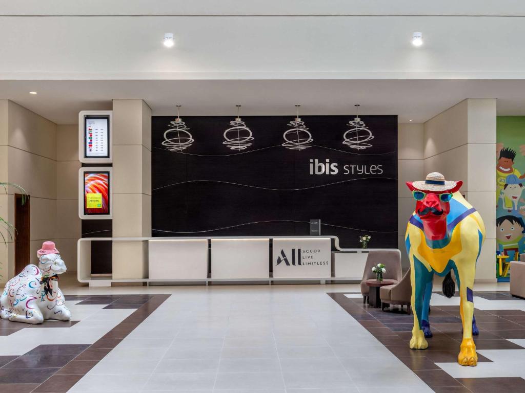 迪拜迪拜龙城宜必思尚品酒店的一间商店大厅,中央有五颜六色的狗雕像