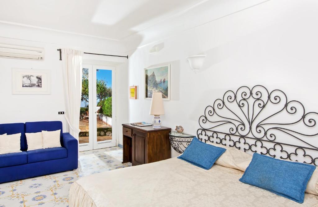 阿纳卡普里加尔迪诺戴尔艺术酒店的一间卧室配有一张床和一张蓝色的沙发