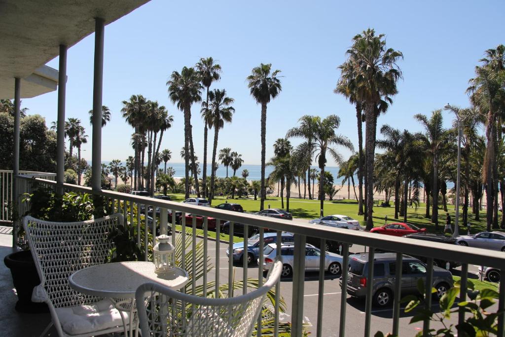洛杉矶贝赛酒店的阳台配有桌椅和棕榈树。