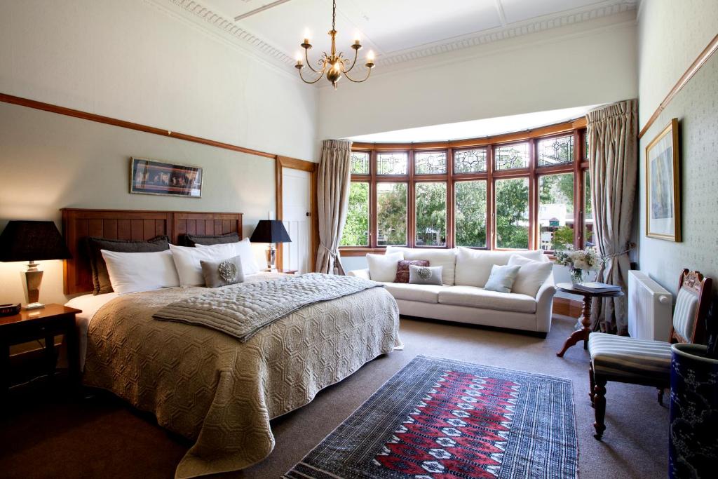 克莱德奥塔哥奥利韦斯中心酒店的一间卧室配有一张大床和一张沙发