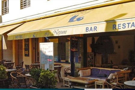 滨海苏拉克Hôtel Le Neptune的餐厅设有长凳和桌椅