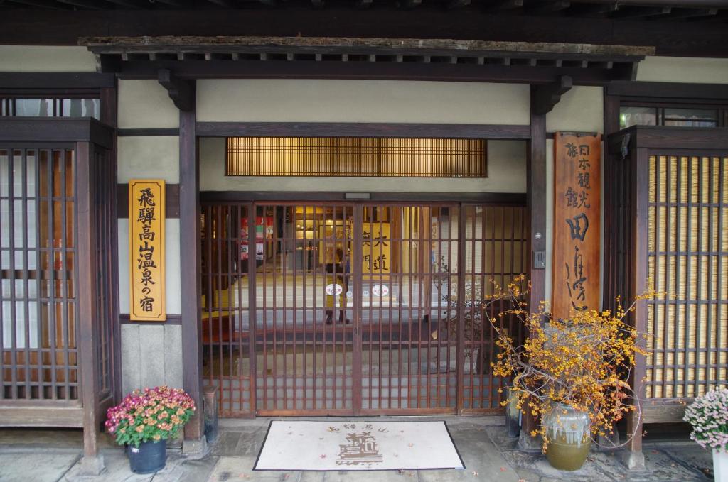 高山田边旅馆的一座带门和鲜花的建筑的入口