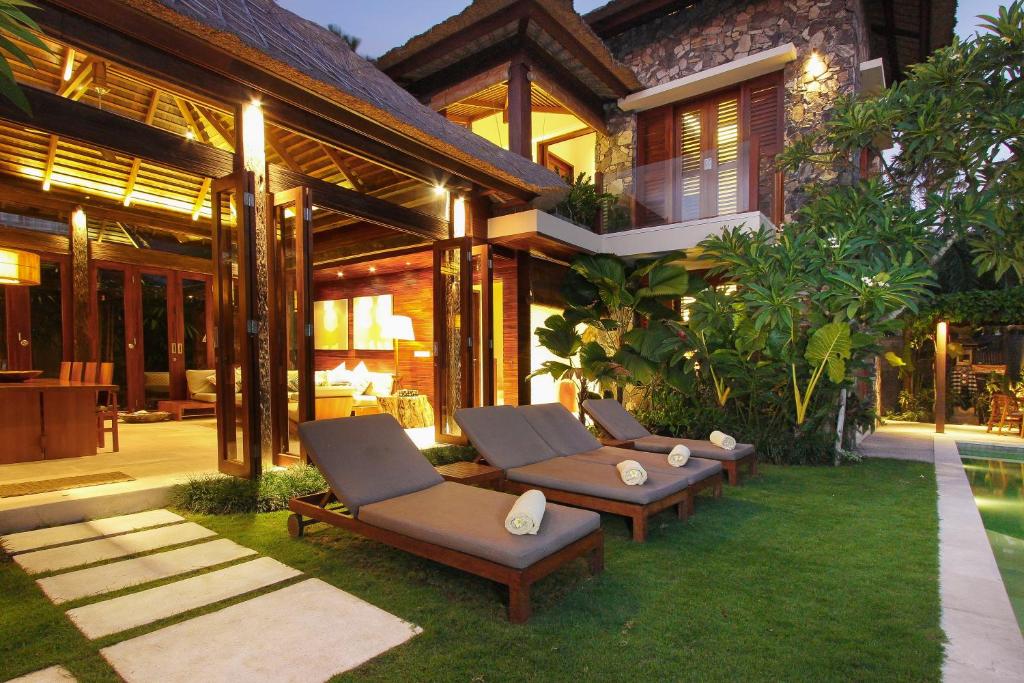 塞米亚克Villa Suar Drupadi的一个带躺椅的庭院和一座房子