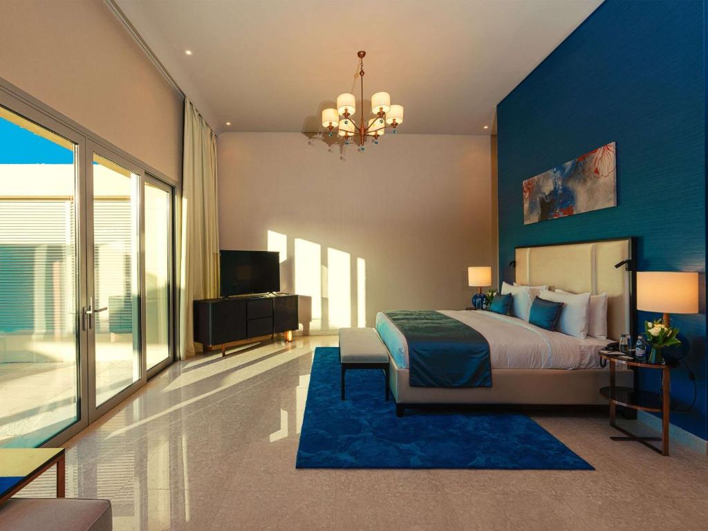 迪拜Rixos The Palm Hotel &amp; Suites - Ultra All Inclusive的一间带床和蓝色墙壁的卧室