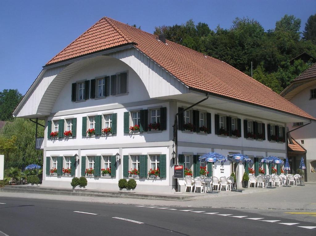 Melchnau加斯索夫鲁汶酒店的街道上一座带桌椅的白色建筑