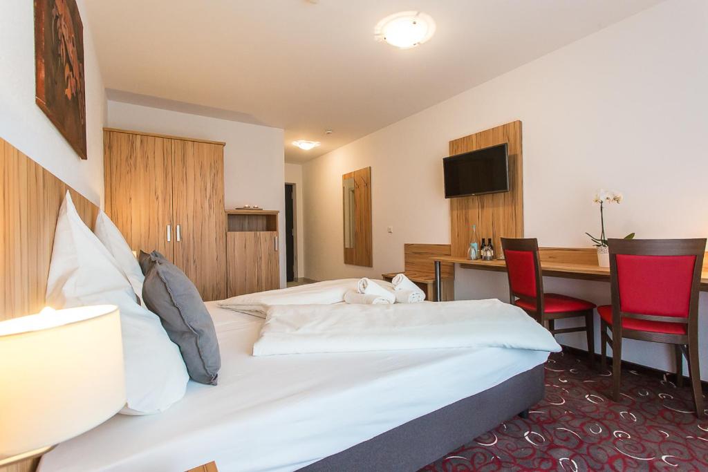 格勒本采尔牧羊人旅馆的酒店客房带一张床、一张桌子和椅子