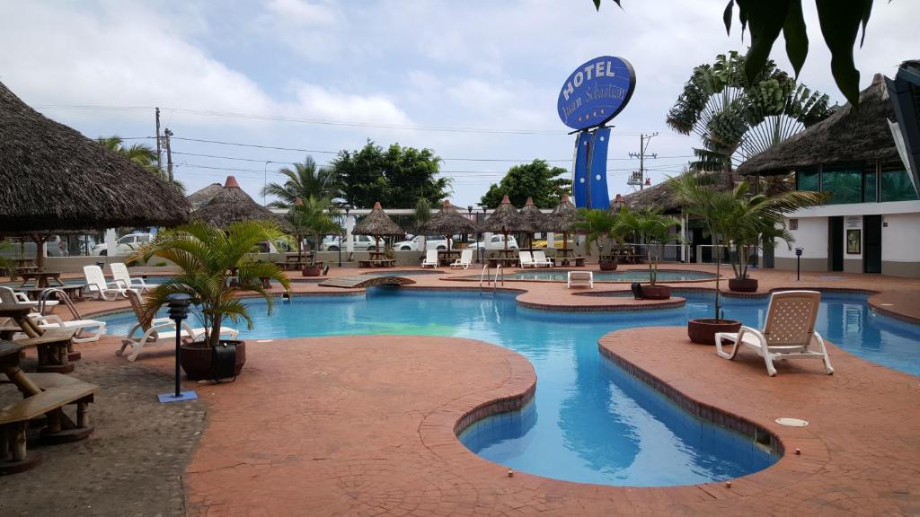 阿塔卡梅斯胡安·塞巴斯蒂安酒店的一个带椅子和标志的度假村游泳池