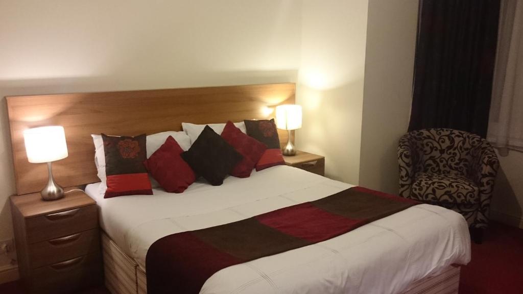 纽波特盖特威快捷酒店的一间卧室配有一张大床,提供红色和黑色的枕头