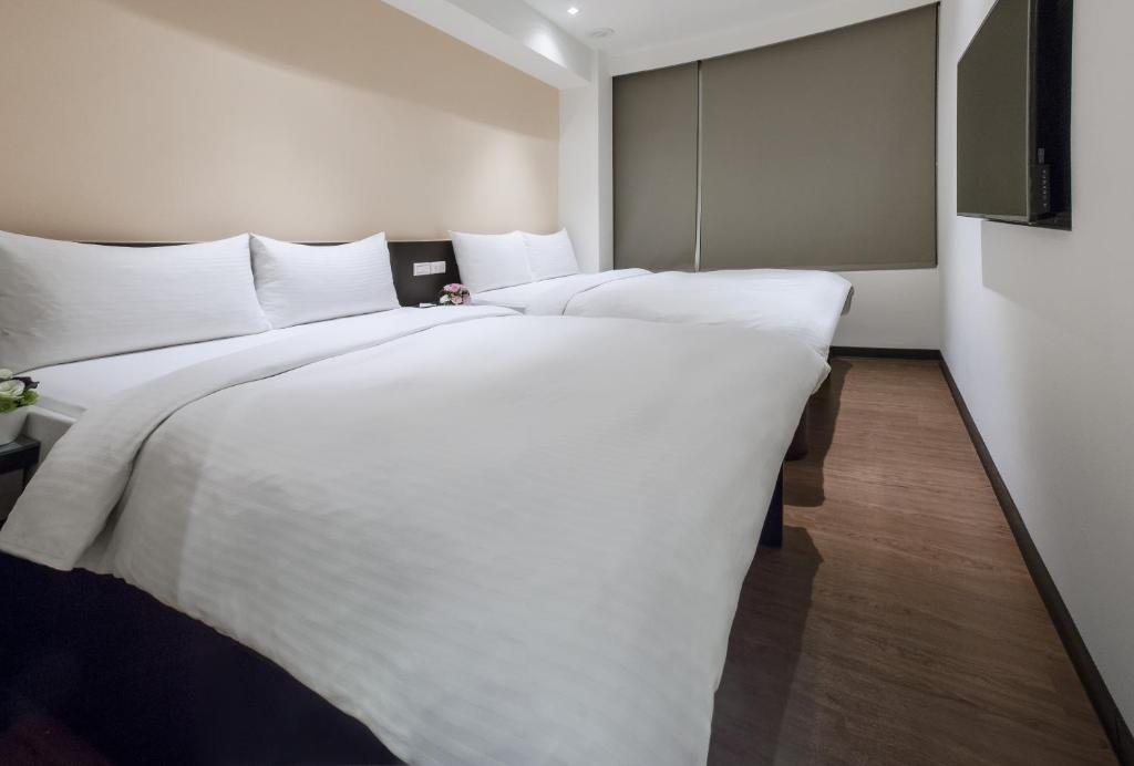 台北橙柊棧 CZ Inn的一张大白色的床,位于酒店客房内