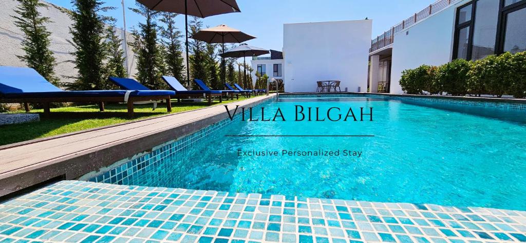 巴库Villa Bilgah Boutique Hotel的一个带蓝色椅子和遮阳伞的游泳池