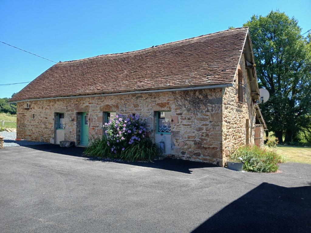 La Roche-lʼAbeilleReids Retreat的一座石头建筑,前面有鲜花