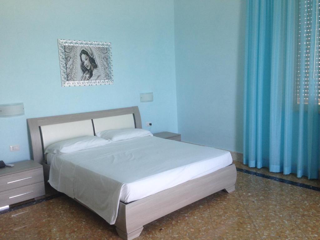 切萨雷奥港Paradise Beach的一间卧室设有一张床和蓝色的墙壁