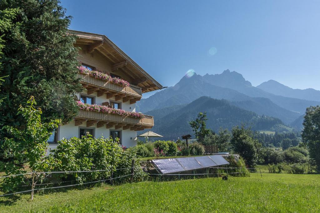 萨菲登安斯泰内嫩米尔福斯特林霍夫旅馆的一座带太阳能电池板的建筑,位于一个有山的田野