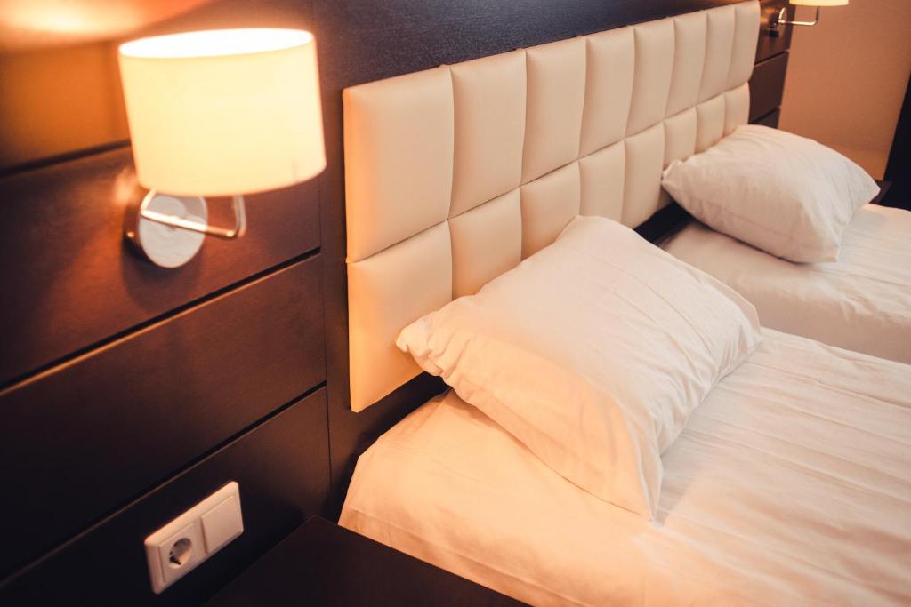 喀山奥斯特洛夫斯基酒店的酒店客房,设有两张床和一盏灯