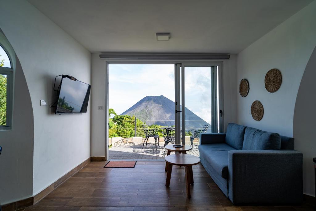 Cerro VerdeHotel Finca Campo Bello的带沙发的客厅,享有山景