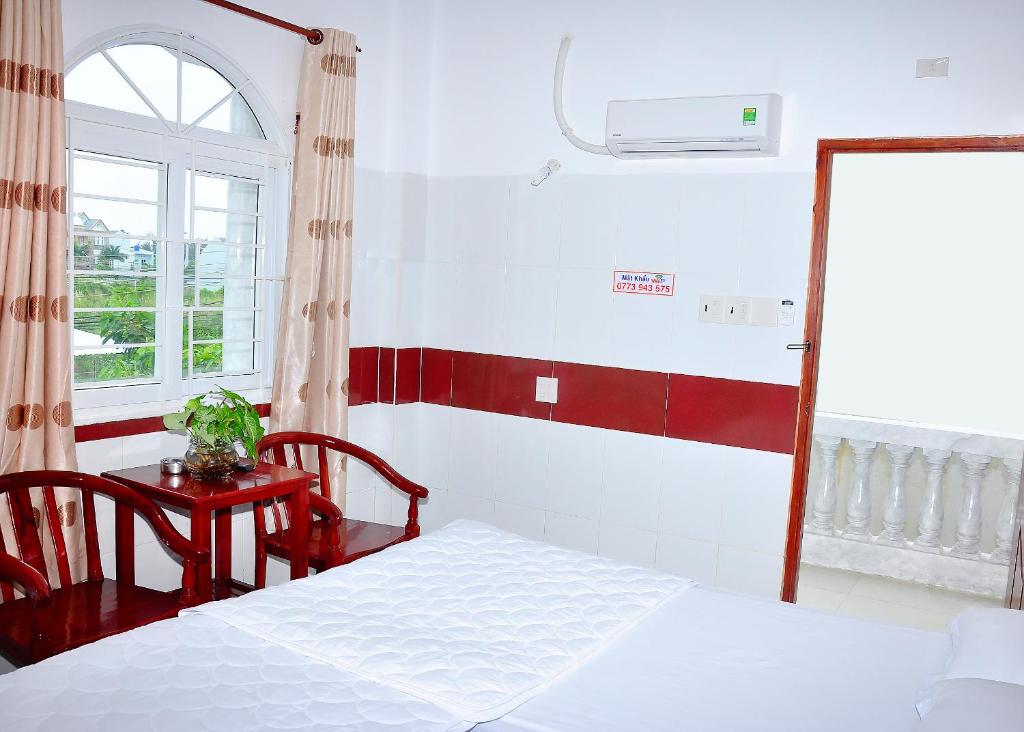 迪石Guest House 36 (2)的一间卧室配有一张床、一张桌子和一个窗户。