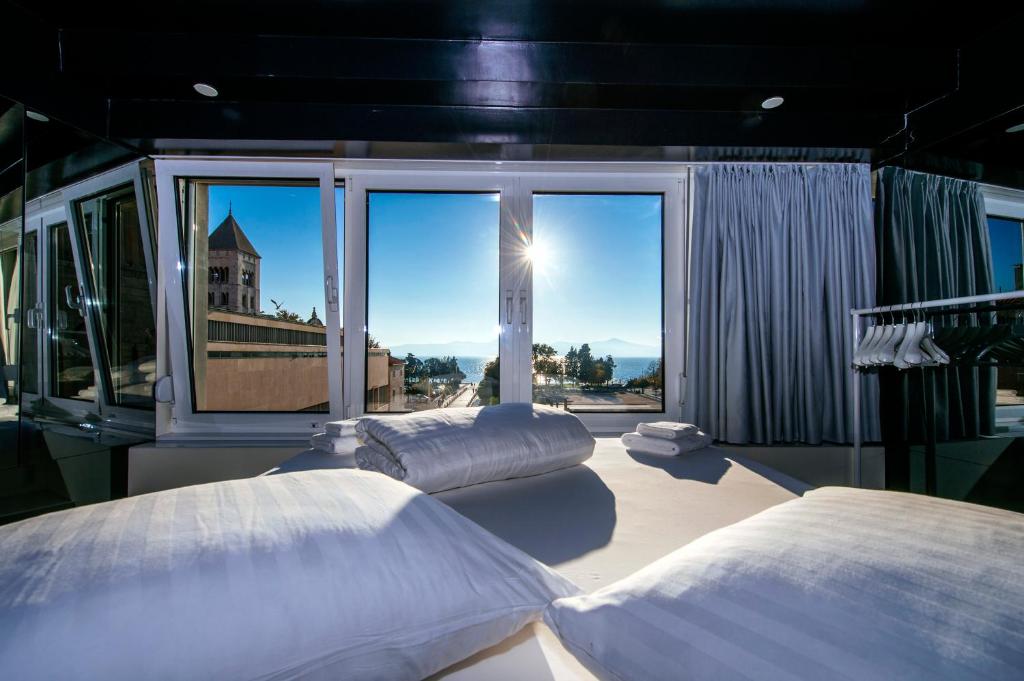 扎达尔广场精品旅馆的带大窗户的客房内的两张床