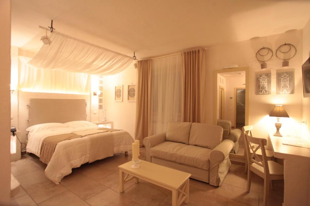 卢切拉Relais in Contrada的一间卧室配有一张床、一张沙发和一张桌子