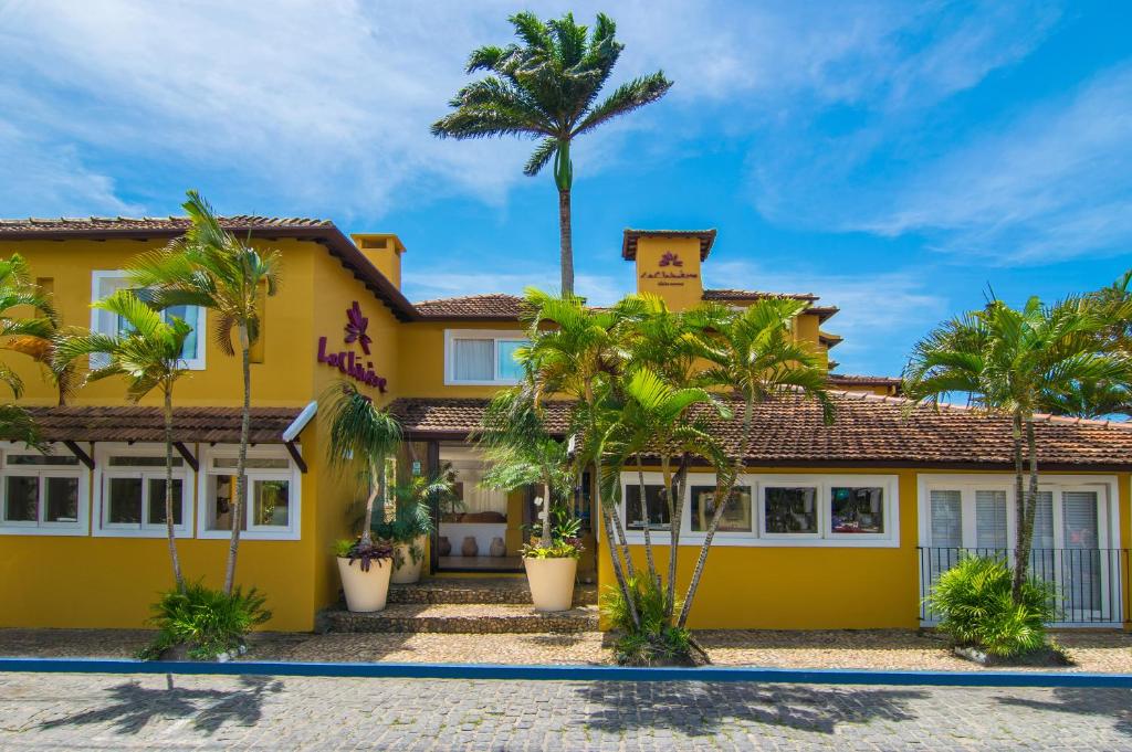 布希奥斯布希奥斯伊森斯彻米尔酒店的棕榈树前方的黄色房子