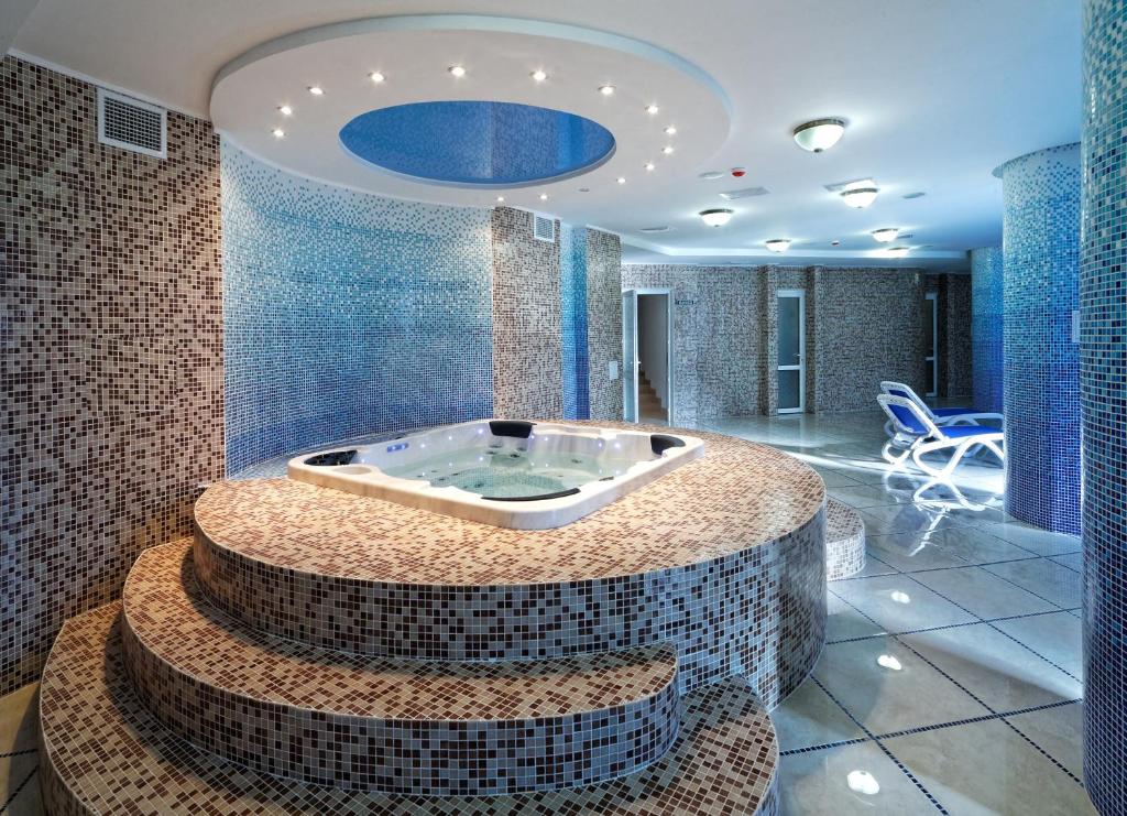 特鲁斯卡韦茨斯维迪亚兹度假酒店的蓝色瓷砖的客房内的按摩浴缸