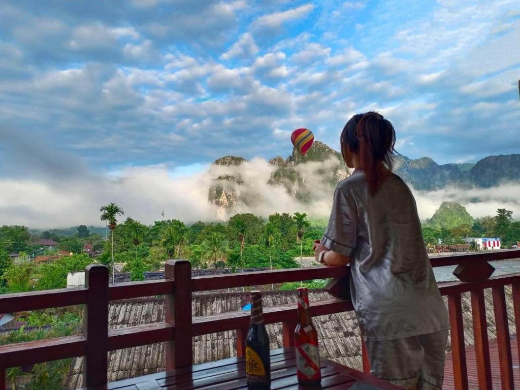 万荣Vang Vieng Hana River View Hotel & Travel的一只在栅栏上放风筝的年轻女孩