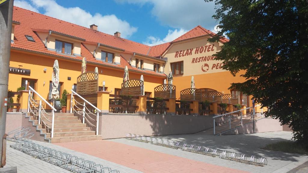 伏尔塔瓦河畔赫卢博卡百利金博卡莱克酒店的餐厅前有楼梯的黄色建筑