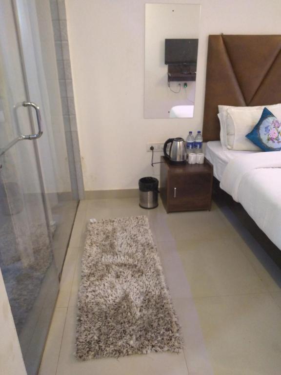 卡兰古特The Balaji inn Baga的卧室配有一张床,地板上铺有地毯