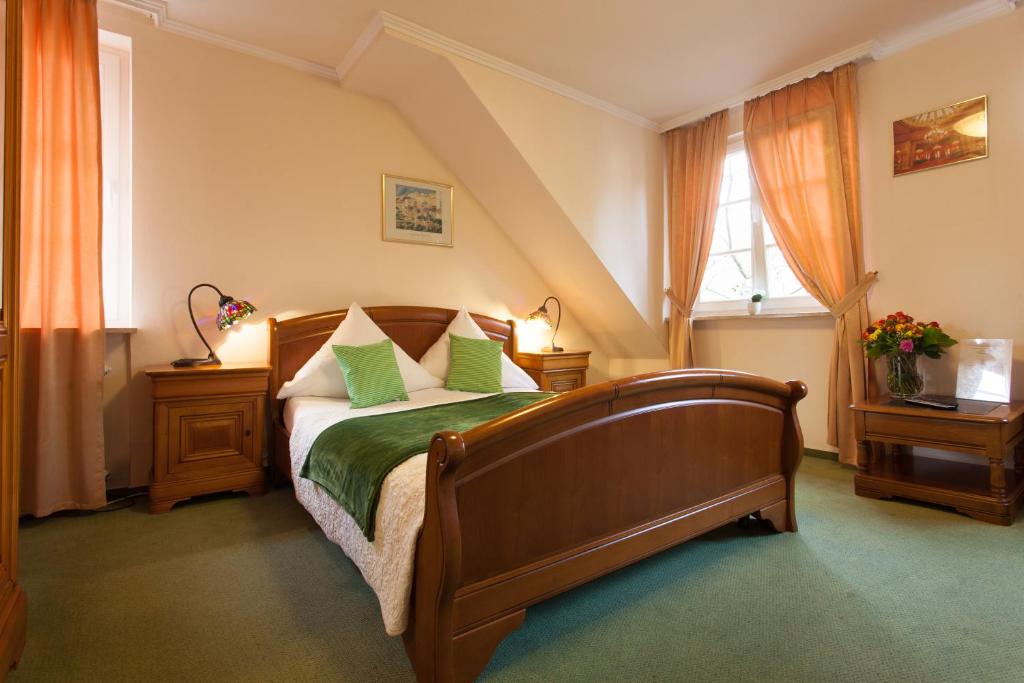 巴登-巴登阿托斯酒店的一间卧室配有一张带绿色枕头的木床。