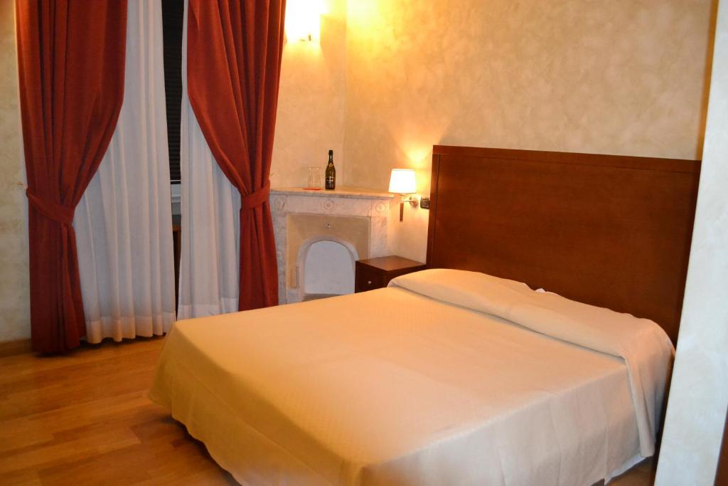 罗马Dipendenza Hotel Galileo的卧室配有白色的床和壁炉
