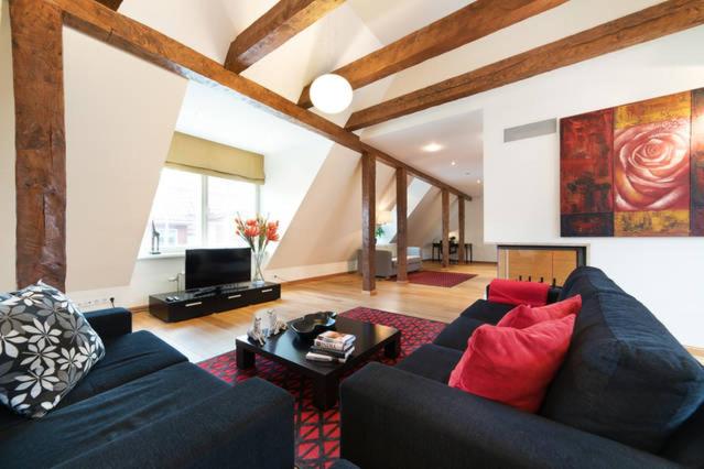 塔林托姆比亚老城塔林市公寓的客厅配有蓝色沙发和红色枕头