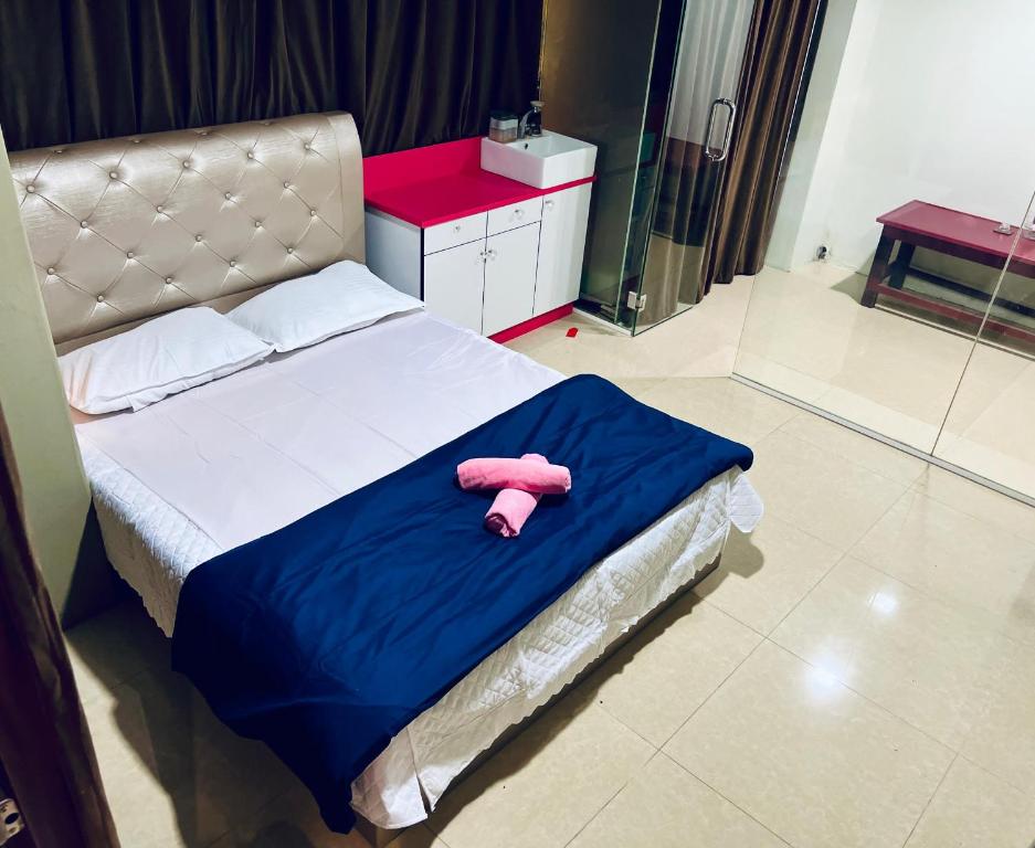 瓜拉丁加奴Homestay Ladang Deluxe Queen Room with Shared Bathroom的躺在床上的粉红色填充动物