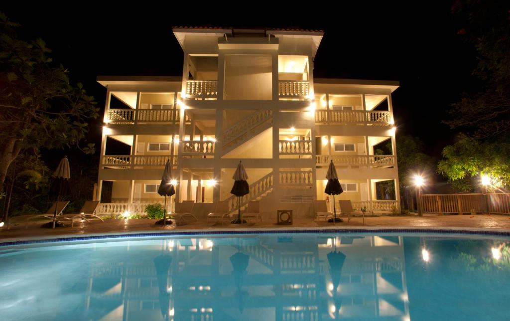 尼格瑞尔桑迪天堂度假村的一座建筑,在晚上前方有一个游泳池