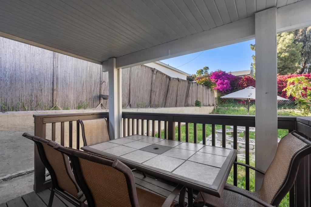 圣地亚哥Downtown Cottage blocks from Petco Park的门廊上的桌椅和桌子
