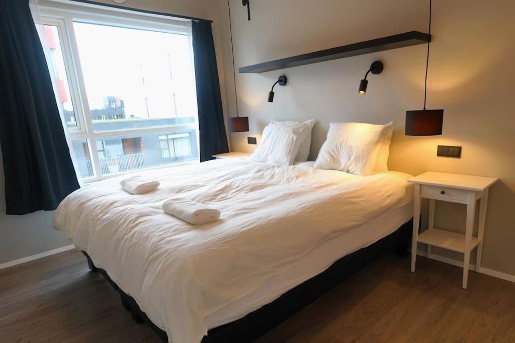 雷克雅未克Modern apartment in great location Reykjavik的卧室配有一张大白色床和窗户