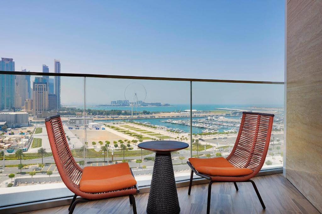 迪拜W Dubai - Mina Seyahi的市景阳台配有2把椅子和1张桌子