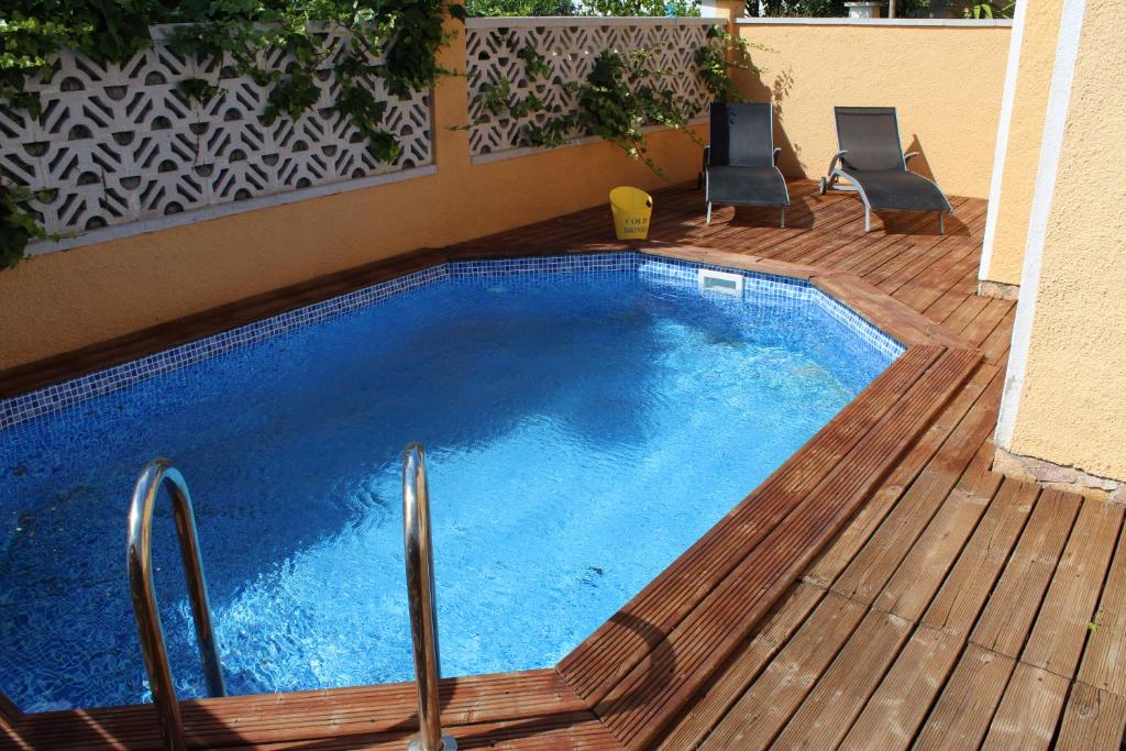 艾姆布里亚布拉瓦Casa Montgri的木制甲板上的游泳池,配有两把椅子