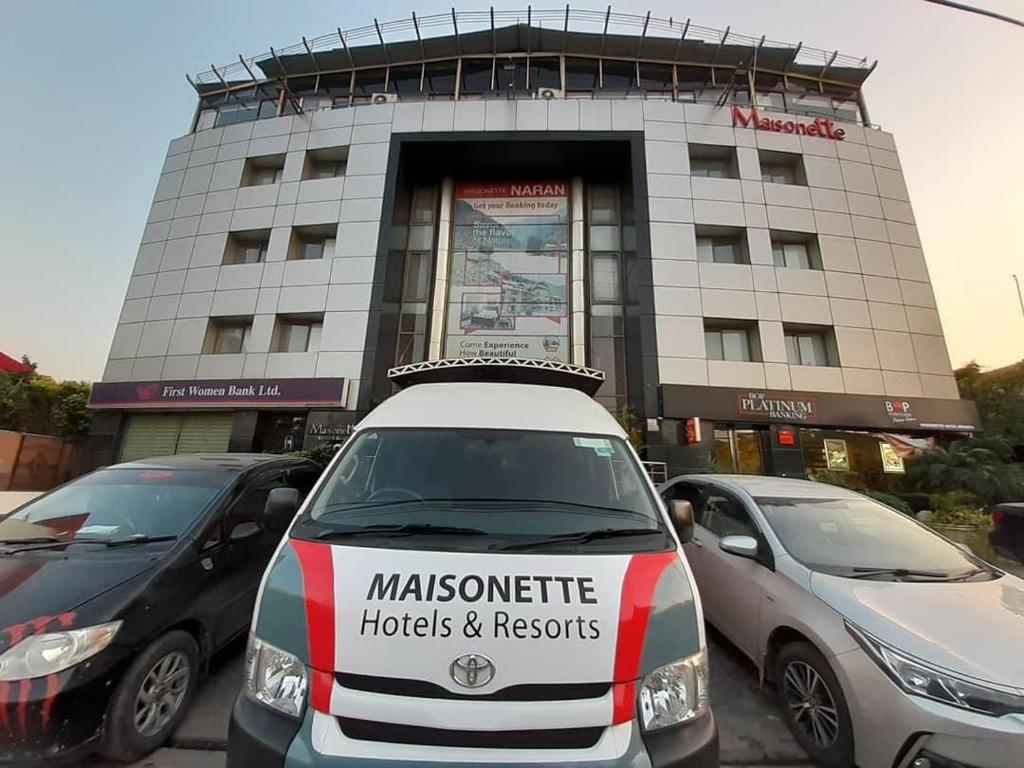 拉合尔Maisonette Hotel & Apartments的停在大楼前的白色汽车