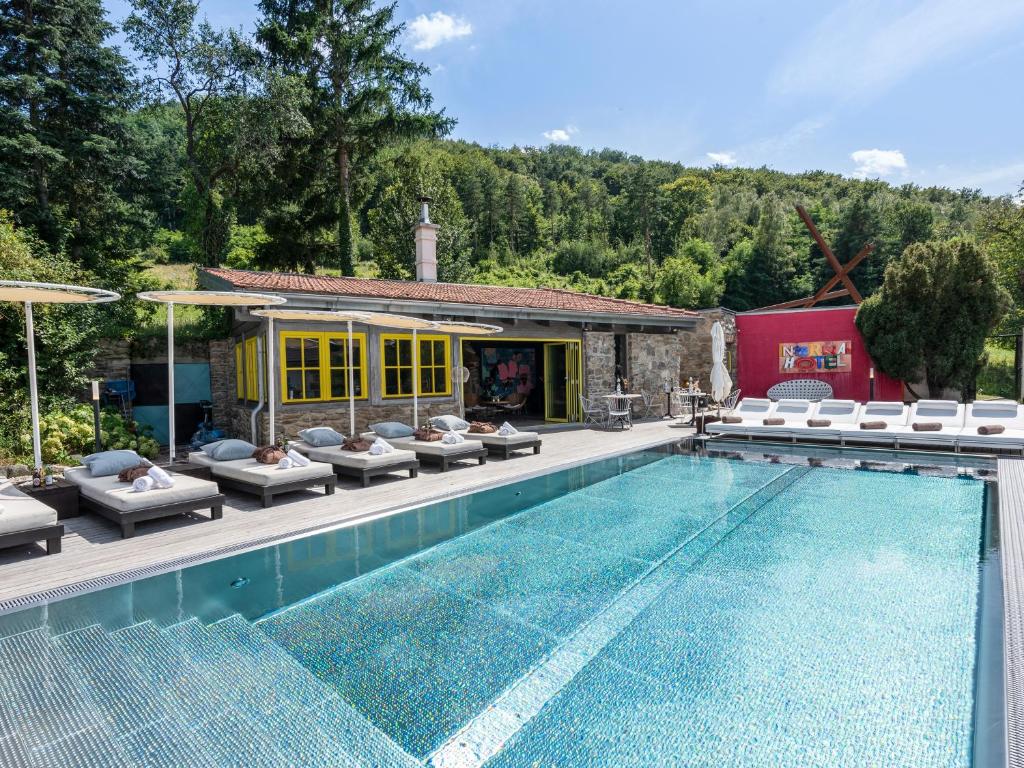 MühldorfLa Petite Ivy, Trenninghof 1302, Wachau - Managed by SKY9 Apartments的一个带椅子的游泳池以及一座房子