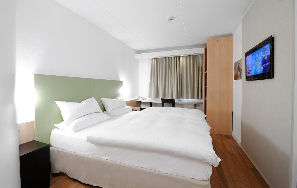 斯德哥尔摩早安希斯塔酒店的卧室配有白色的床和电视。