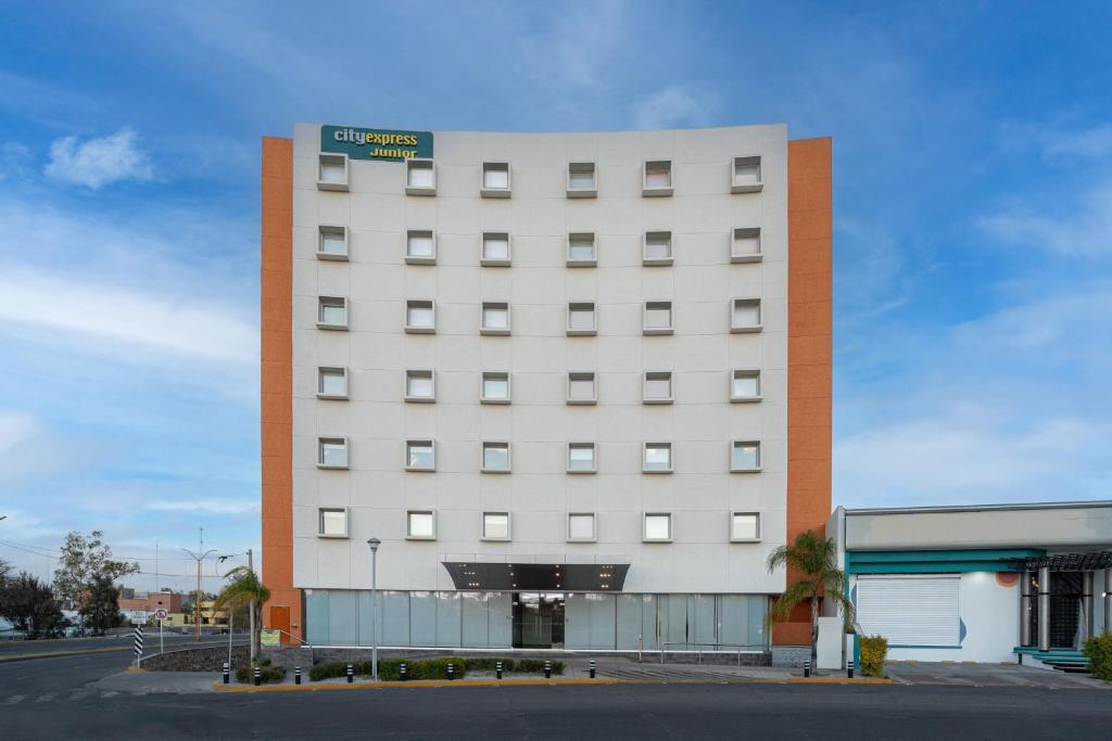 阿瓜斯卡连特斯City Express Junior by Marriott Aguascalientes Centro的白色的建筑,上面有标志