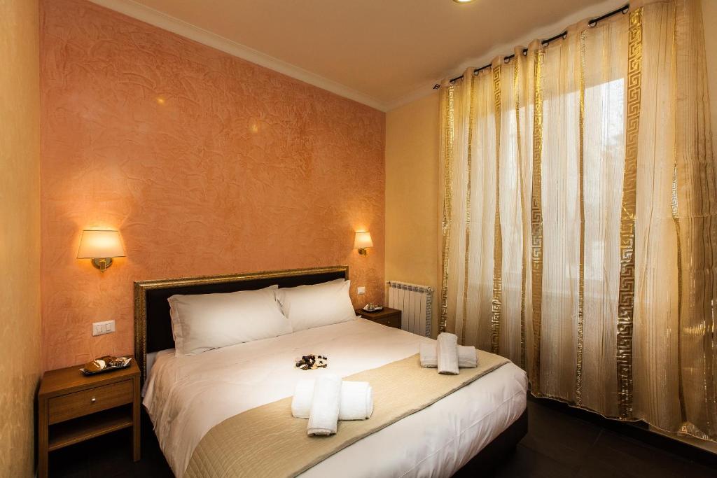 罗马天堂旅馆的一间卧室配有一张床,上面有两条毛巾